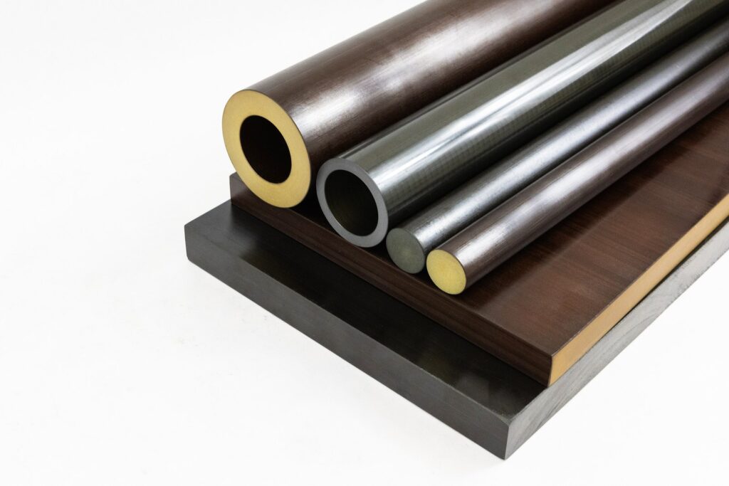 Seamless Tube en Torlon présenté aux côtés de semi-produits en Torlon (barres rondes et plaques)